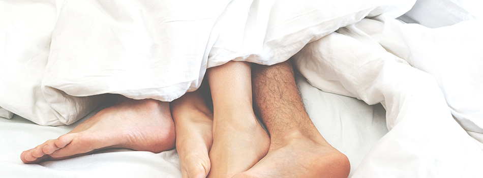 ベッドから足を出す男女