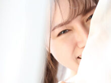 カーテンに隠れる女性