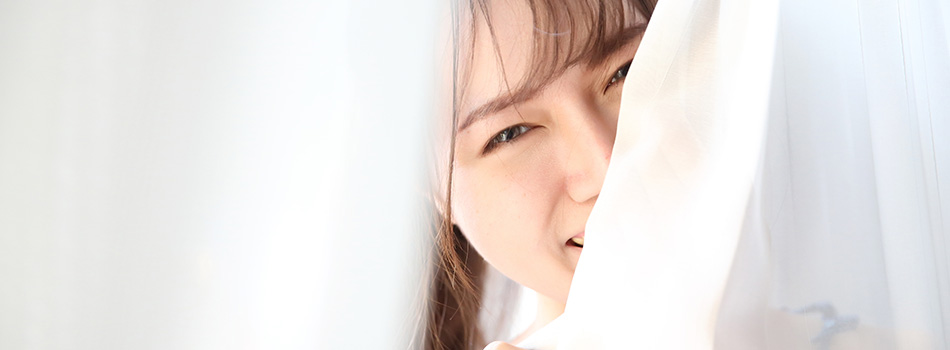 カーテンに隠れる女性